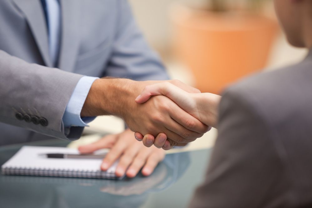 Two Businesspeople shaking hands indoors-1